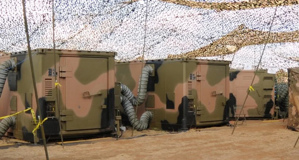 Camouflaged deployable military shelters under netting, the hero image of the PowerShield Daronmont case study