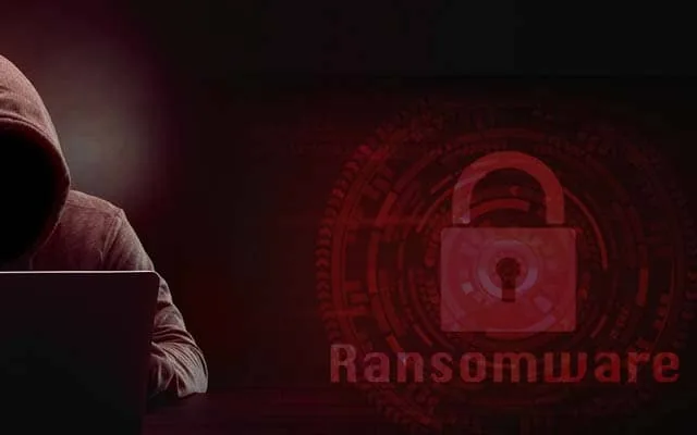 Hooded figure in front of a ransomware padlock graphic