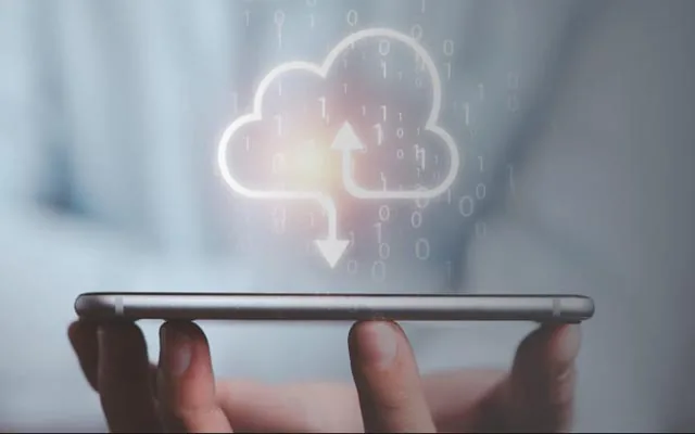 Hand holding a phone with a cloud upload icon above it