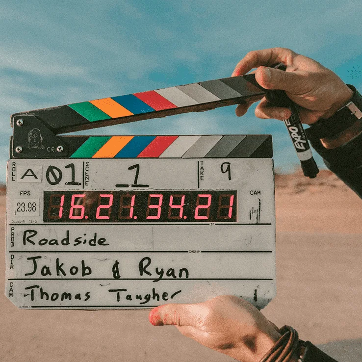 Video creator holding a clapperboard on set