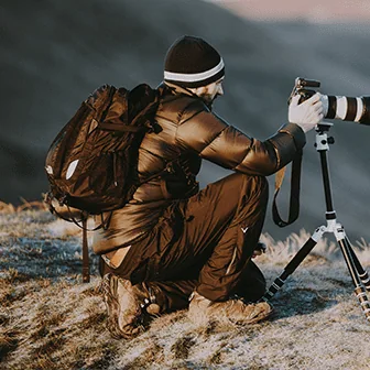 Photographer with a camera and tripod outdoors