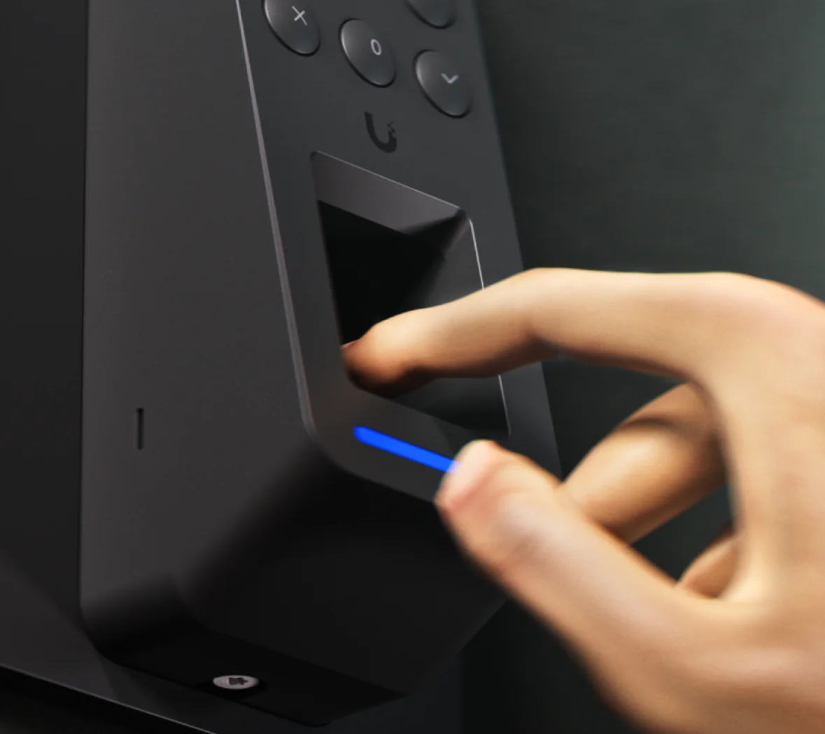 Finger placed on the capacitive fingerprint sensor of a black UniFi Access fingerprint reader