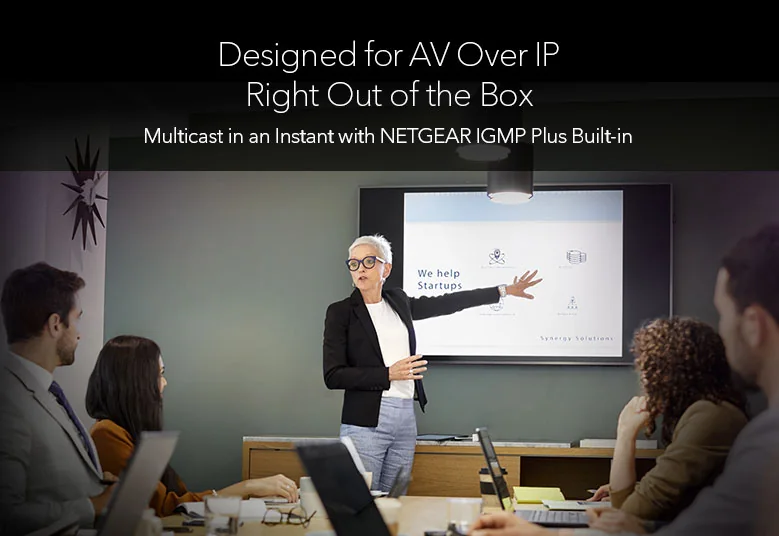 Presenter in a meeting room with a display, the setting for the fanless Netgear GSM4210PD desktop AV switch
