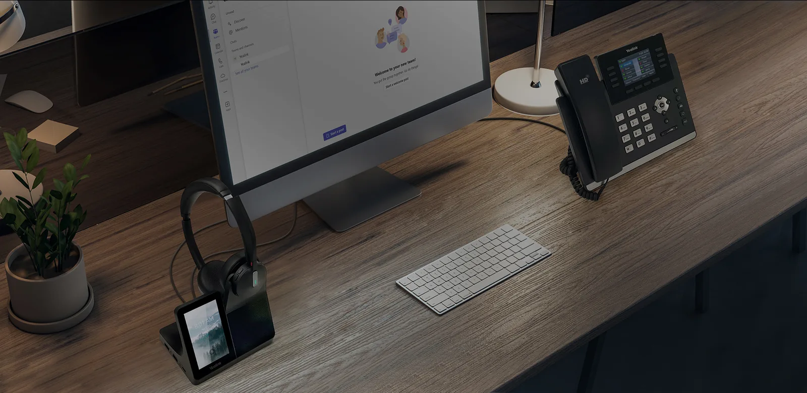Yealink desk phone and DECT headset on its base on an office desk