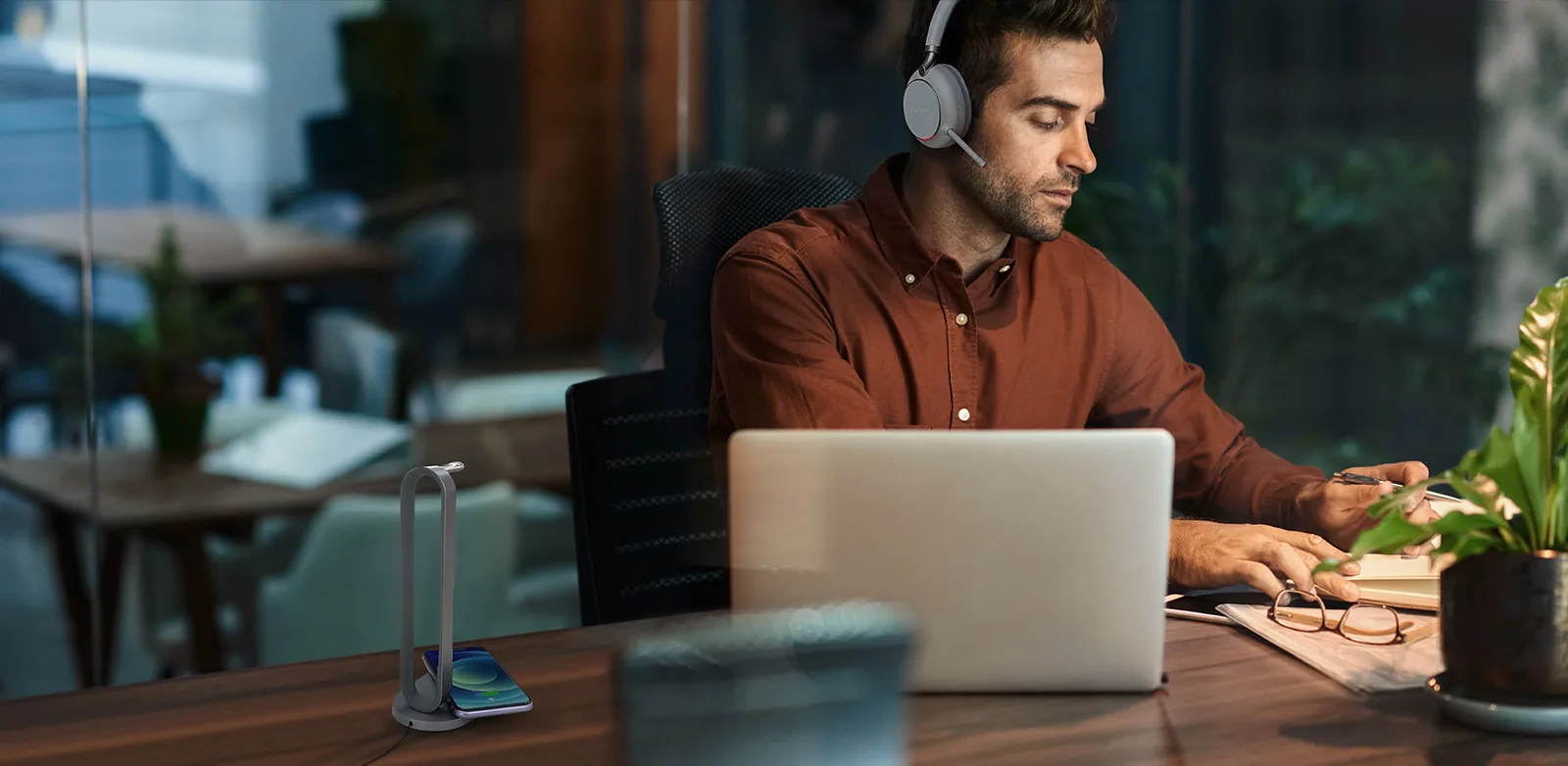 Hybrid worker on a call with a Yealink Bluetooth headset at a laptop