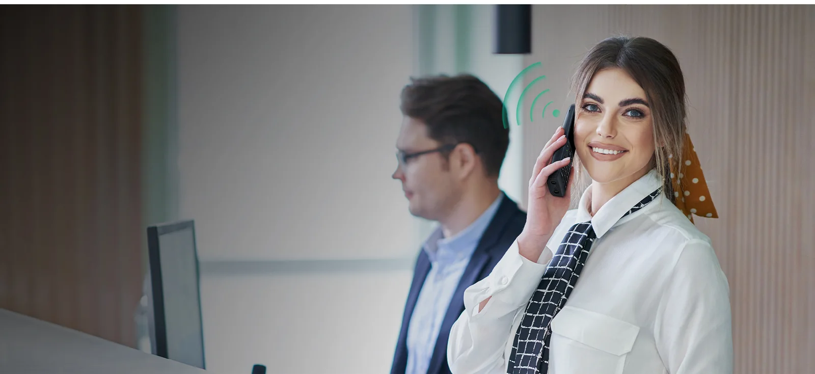 Front-office staff member taking a call on a Yealink AX83H Wi-Fi handset