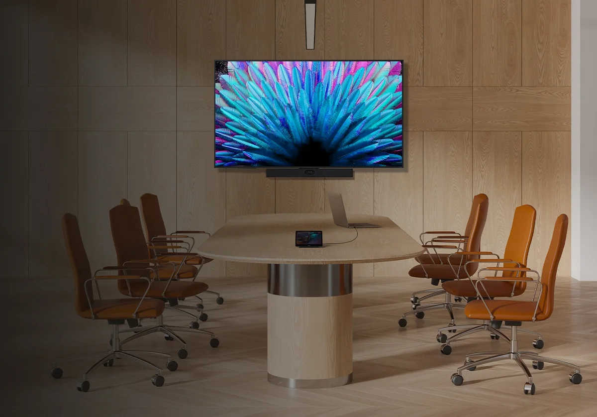 Yealink MeetingBar A40 under a wall display in a meeting room with a round table