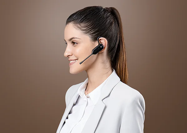 Woman wearing a Yealink convertible DECT headset with the ear hook