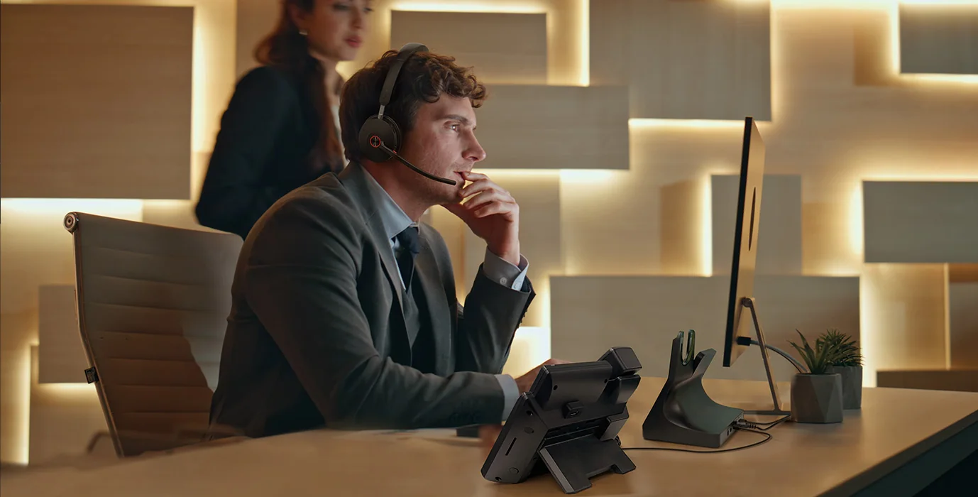 Manager on a call with a Yealink WH68 Workstation DECT headset and touch-screen console